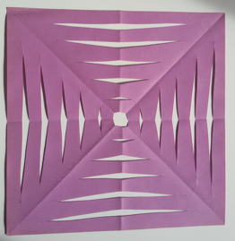 Foto eines Faltschnittes aus violettem Papier. Entstanden ist ein Quadrat mit einer symmetrischen Musterung.