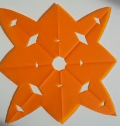 Foto eines Faltschnittes aus orangenem Papier. Entstanden ist eine sternförmige Figur.