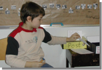 Foto eines Kindes, dass gerade einen Zettel in den Mathebriefkasten steckt.