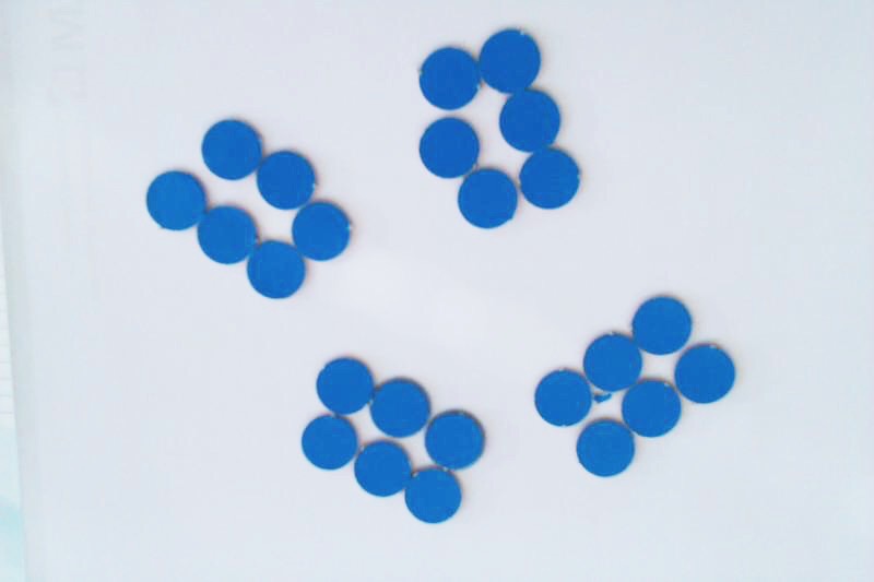 Foto von blauen Plättchen, die zu 4 Gruppen mit jeweils 6 Plättchen angeordnet wurden.