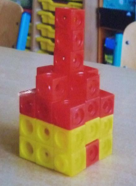 Foto eines Gebäudes aus roten und gelben Steckwürfeln.