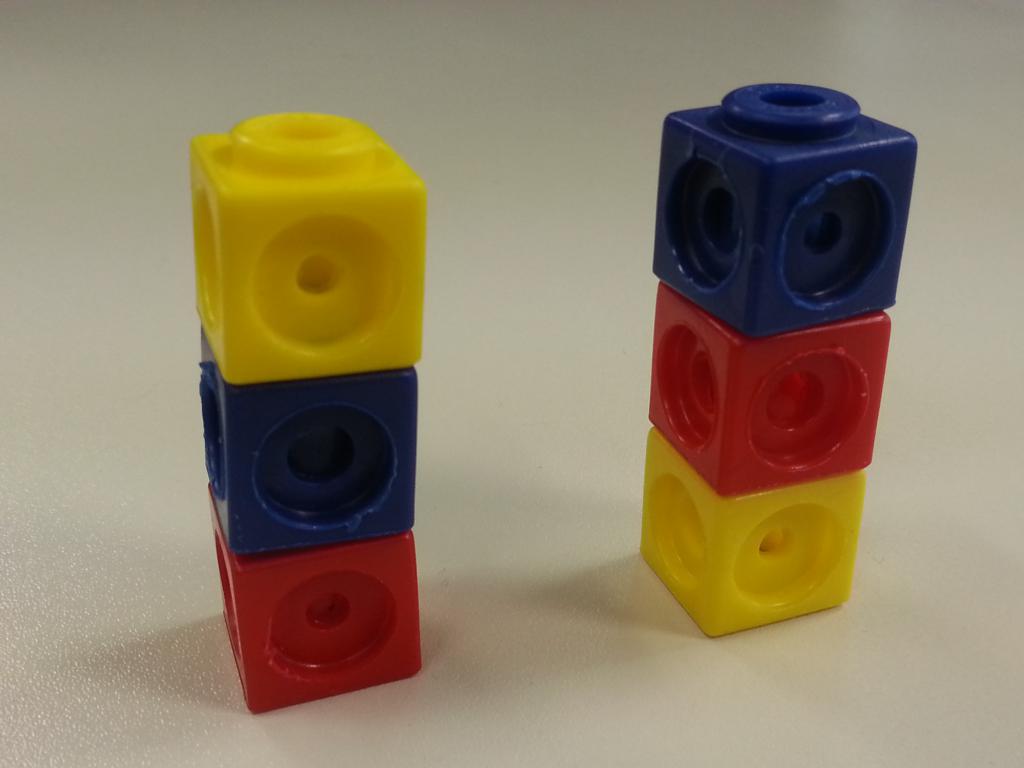 Foto von 2 ähnlichen Steckwürfeltürmen: Links: rot, blau, gelb. Rechts: gelb, rot blau.
